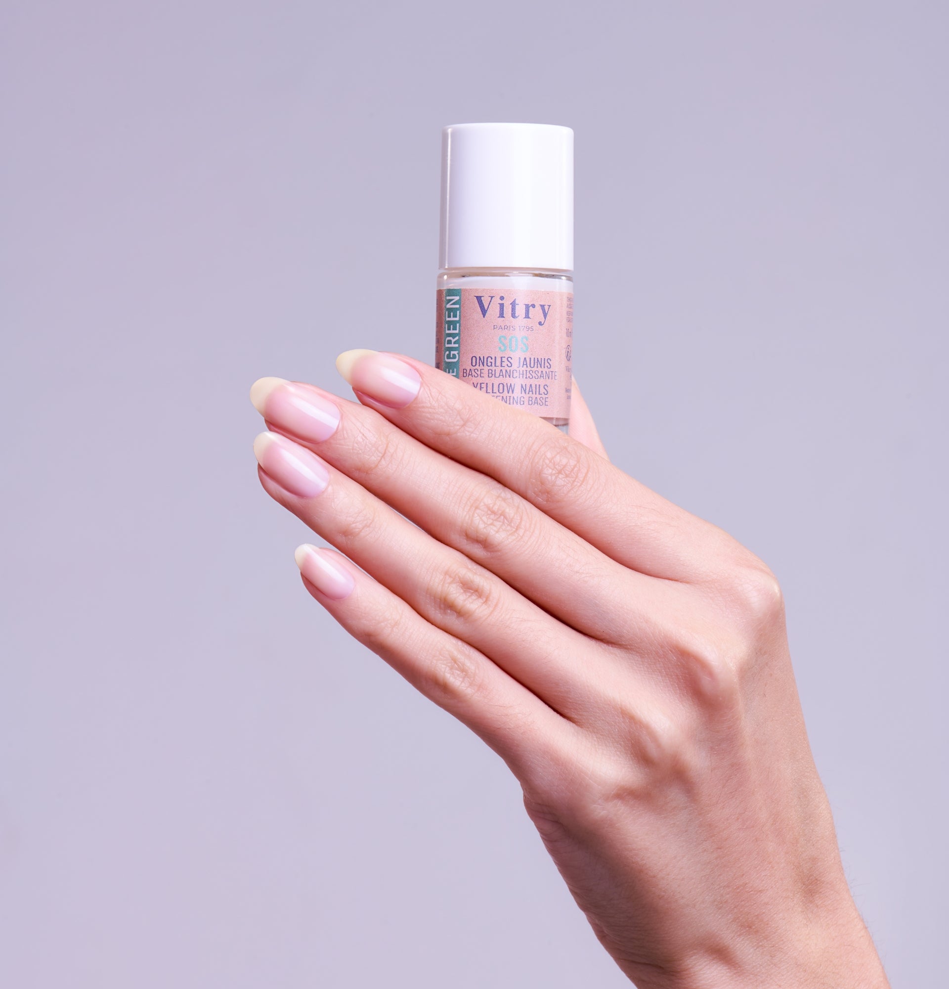 Main montrant le flacon la Base blanchissante SOS Ongles Jaunis VITRY flacon transparent pour ongles éclatants – réf. VGBLAN