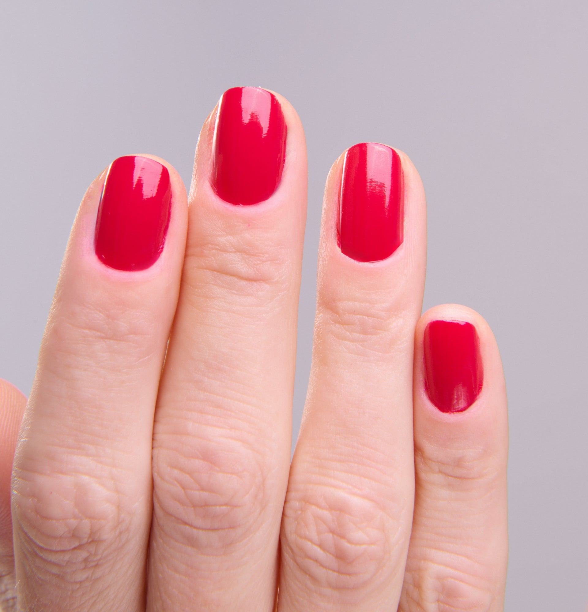 Main portant le vernis Be Green Burgundy. Réf. VGREE085