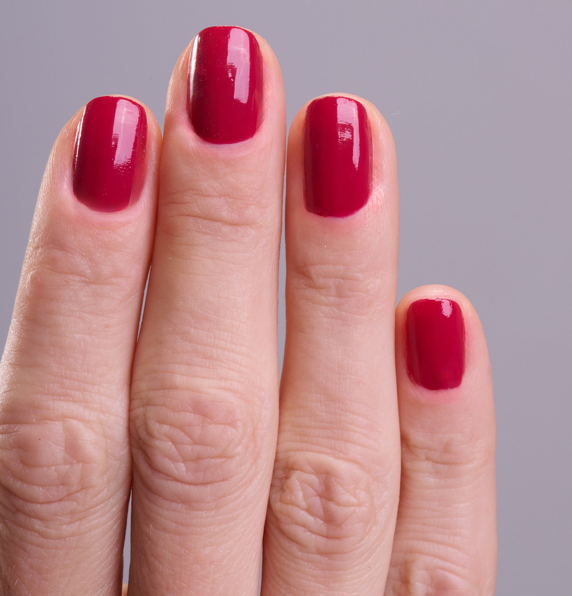 Main portant le vernis Be Green Magenta. Réf. VGREE098