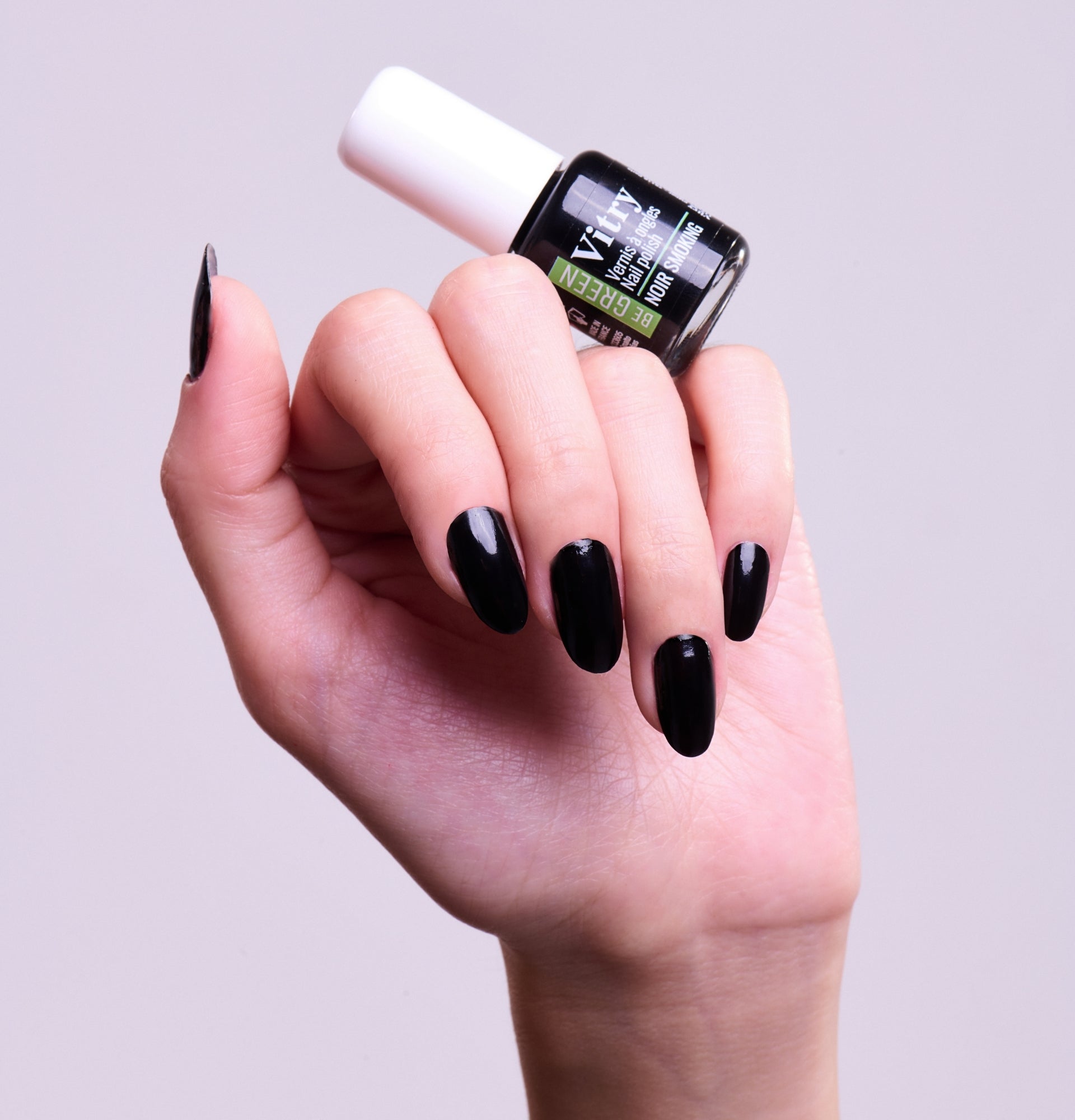  Main portant le flacon 6ml Vernis Be Green Noir Smoking. Réf. VGREE109