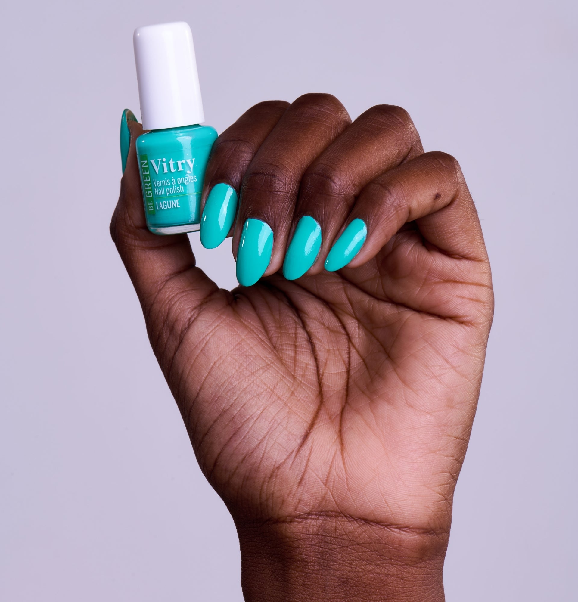 Main portant le flacon 6ml Vernis Be Green Lagune. Réf. VGREE111