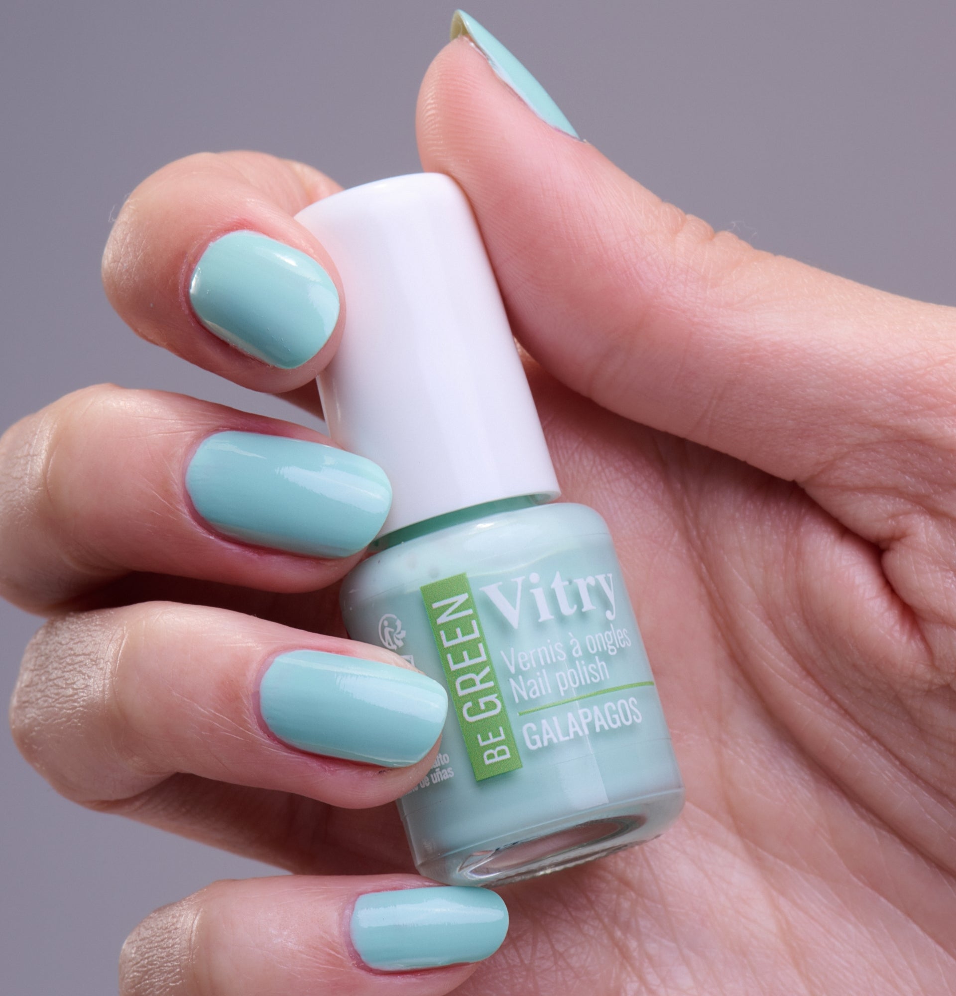 Main portant le flacon 6ml Vernis Be Green Galapagos. Réf. VGREE121