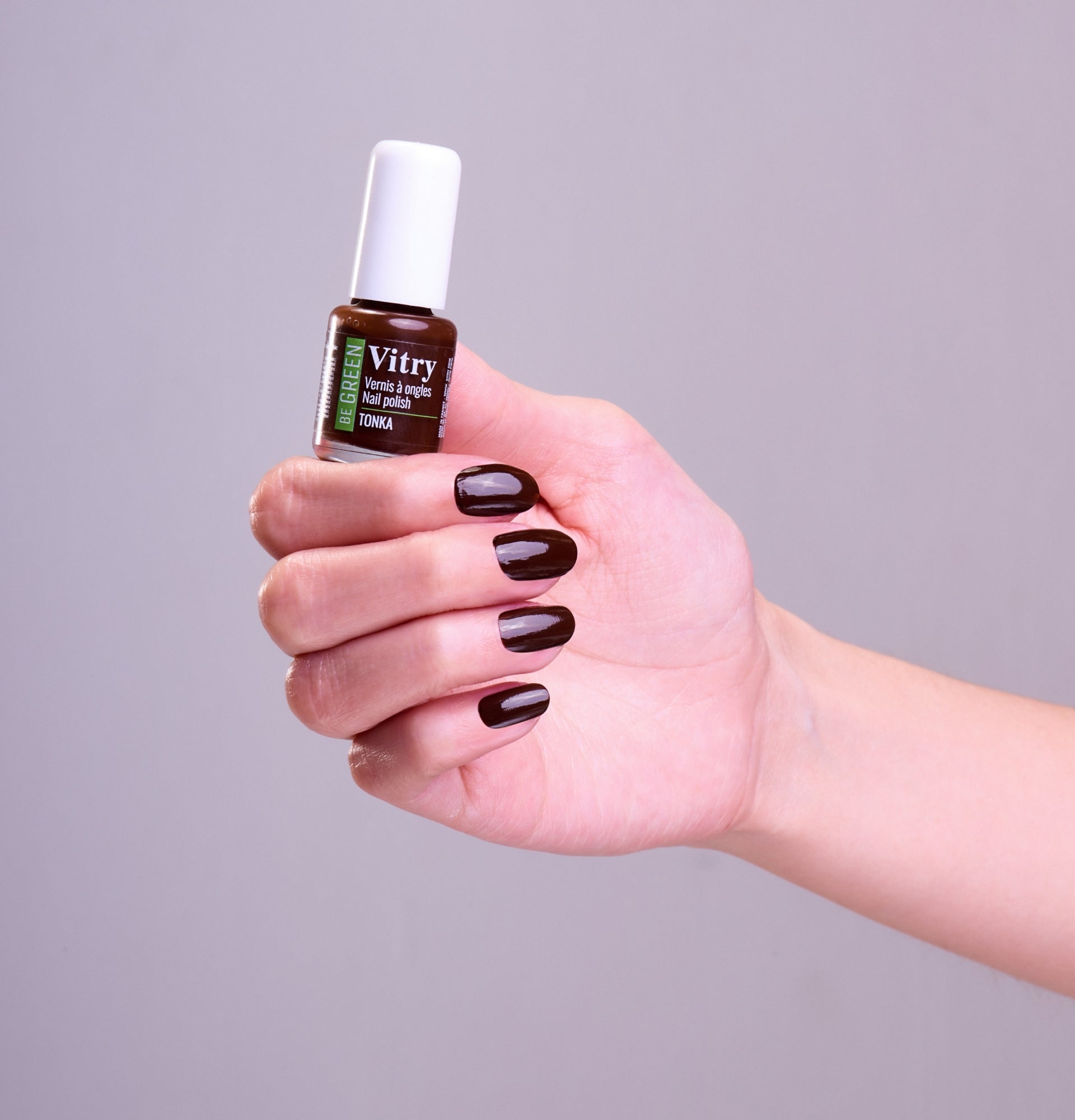 Main portant le flacon 6ml vernis à ongles Be Green Tonka. Réf VGREE126